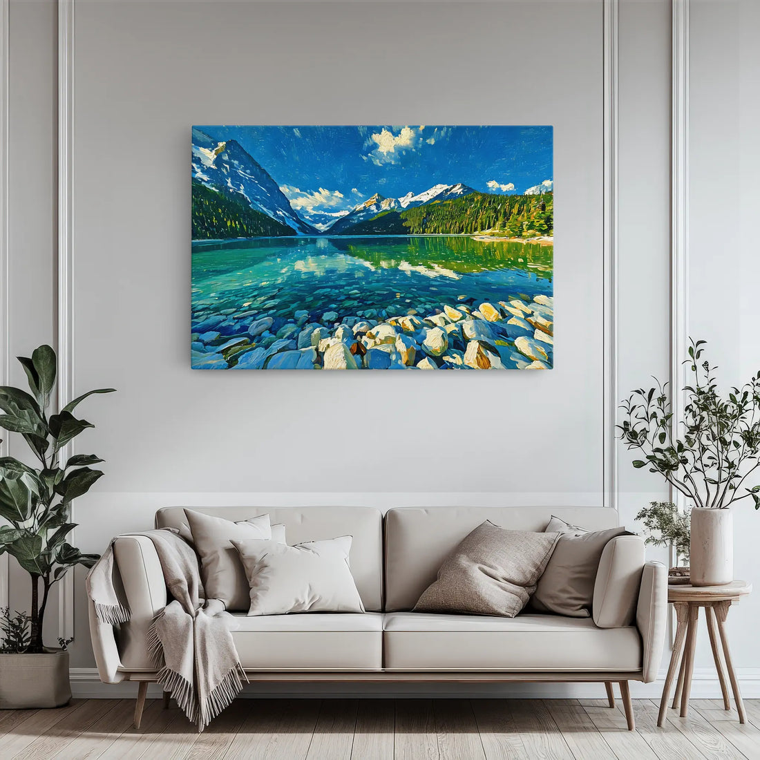 A serene landscape painting of a lake with mountains and a clear blue sky, displayed above a modern beige sofa with cushions and a throw blanket.
