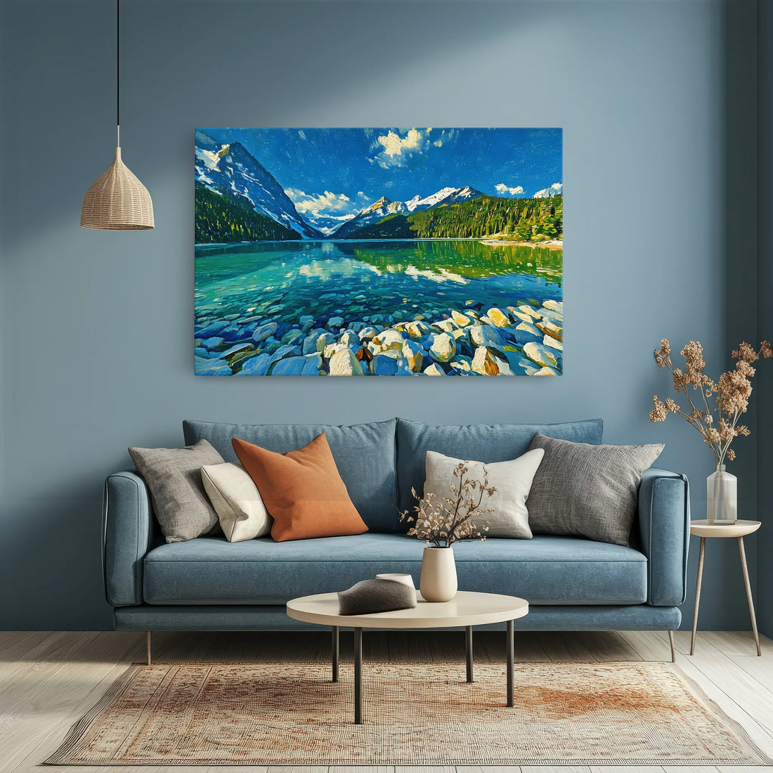 A cozy living room with a blue sofa, assorted pillows, a round coffee table, and a landscape painting of a lake and mountains on the wall.