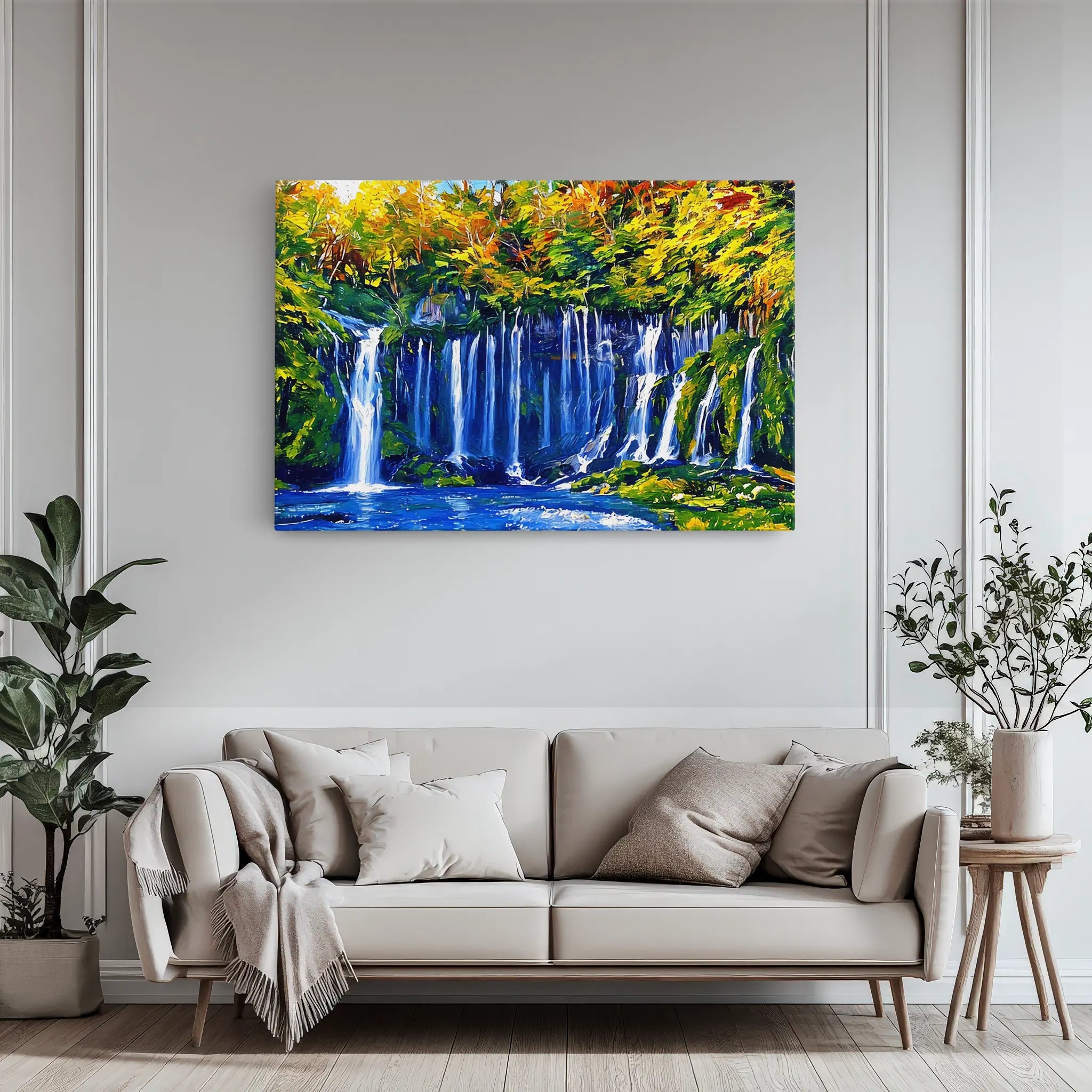 A vibrant painting of a waterfall with lush greenery and autumn foliage, displayed above a modern beige sofa in a stylish living room.